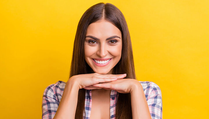 brunette women with white teeth on a yellow background