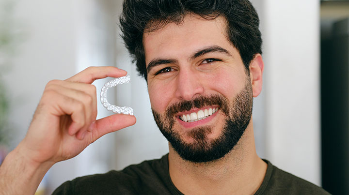 man holding invisalign piece
