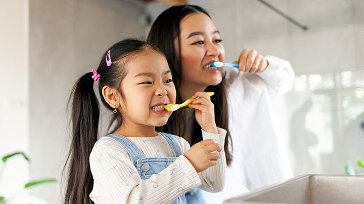 mom child brushing teeth